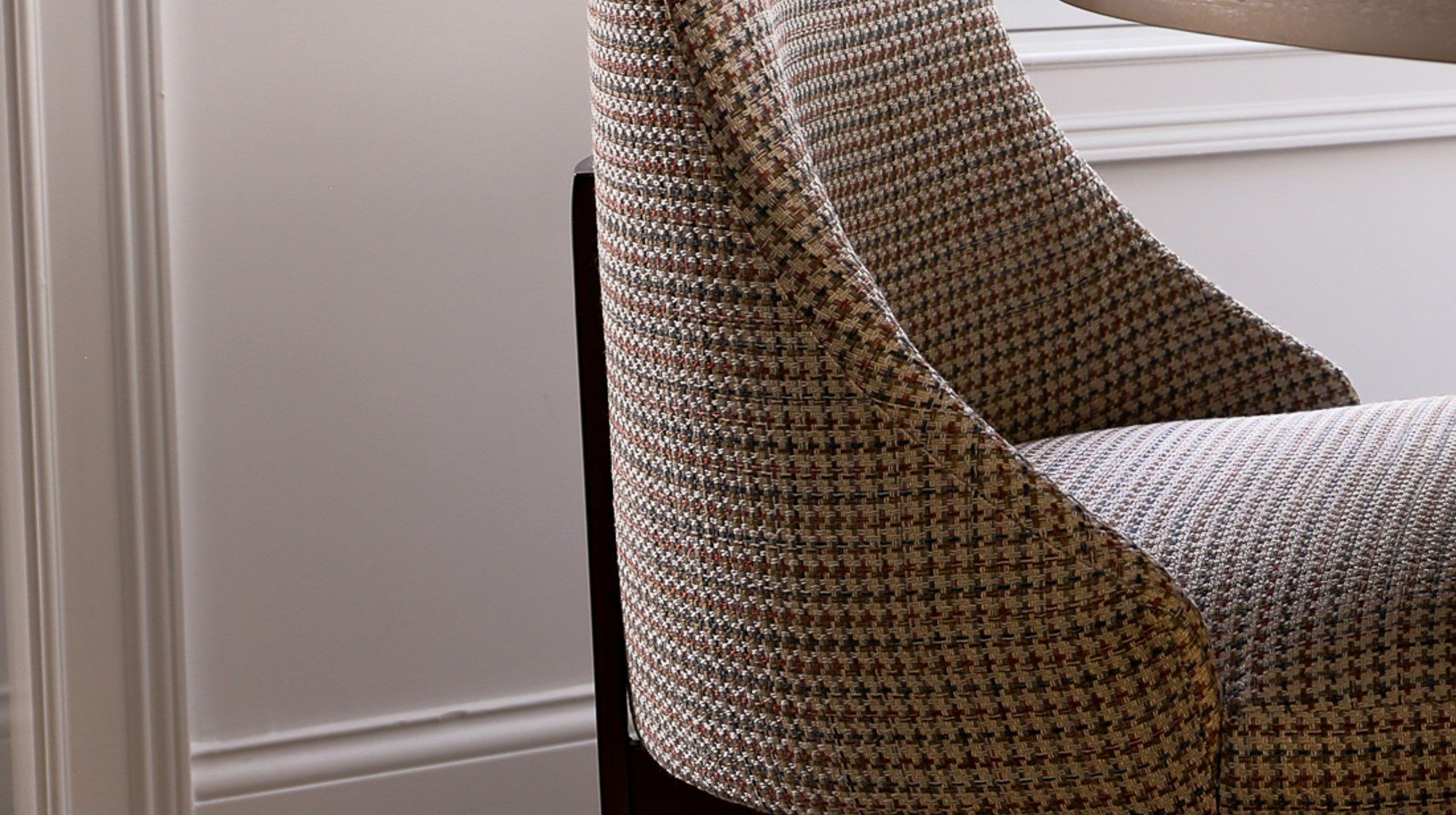 Close detail of rust-and-taupe houndstooth upholstery fabric on a reupholstered dining chair